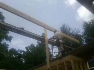 Carpenter setting a ridge beam over a new addition frame — Ice Dam Removal by Roofing Brothers in Peoria
