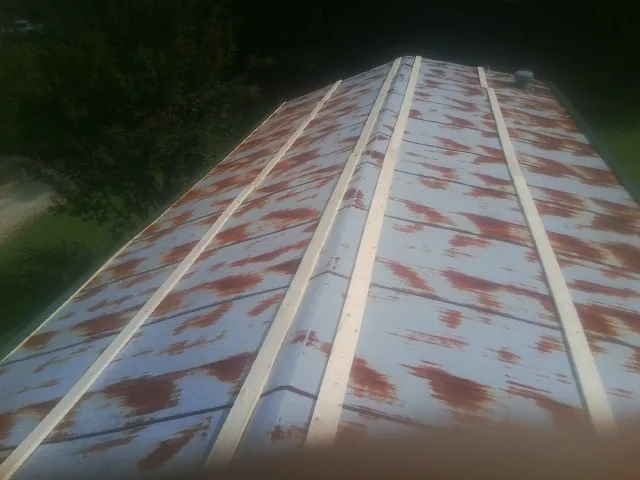 Rusted metal roof panels with new wood purlins before replacement — Storm Damage Roof Repair in Peoria by Roofing Brothers