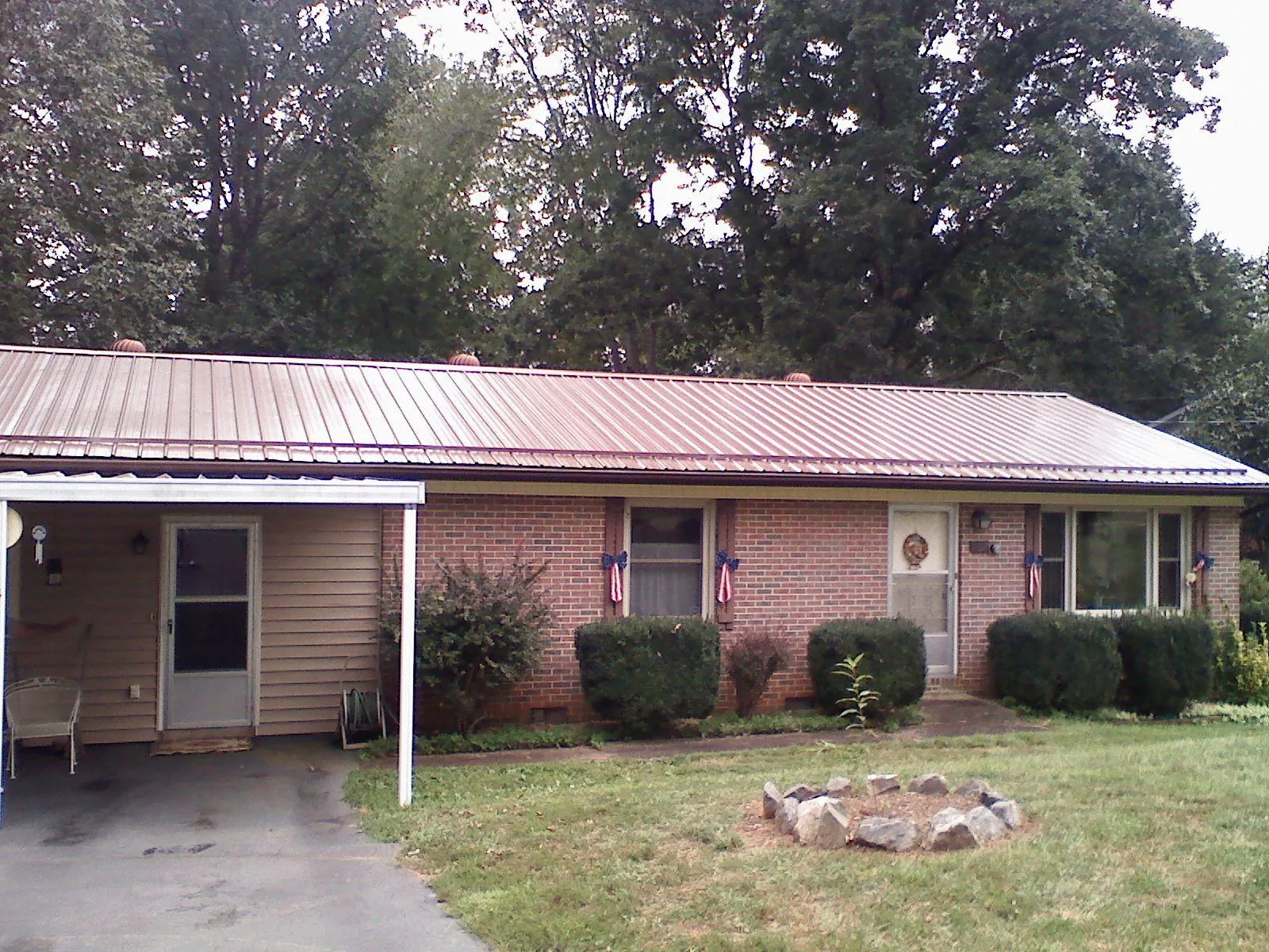 Bronze metal roof and carport on a brick ranch home — Roof Repair work by our crew in Peoria